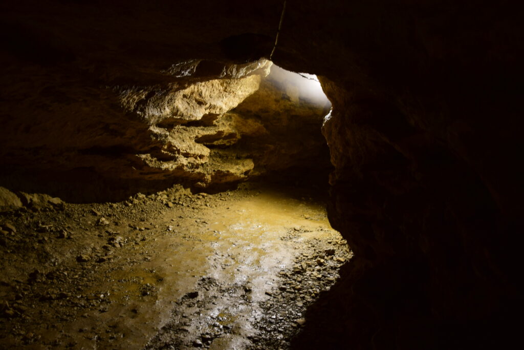 Foto di una delle grotte buie, illuminate sotto un anfratto ad arco